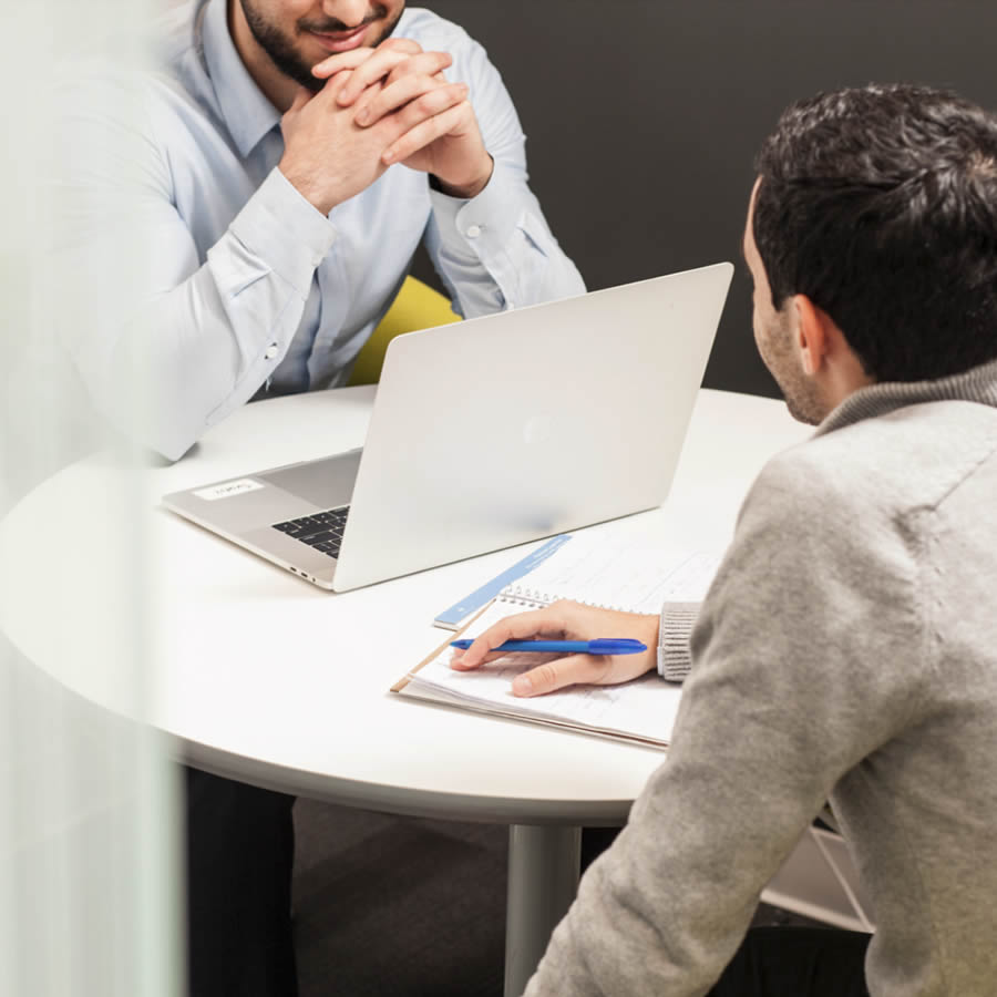 two-male-colleagues-seated-at-table-talking