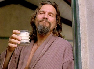 Image of The Dude from the film The Big Lebowski holding a glass of milk smiling.